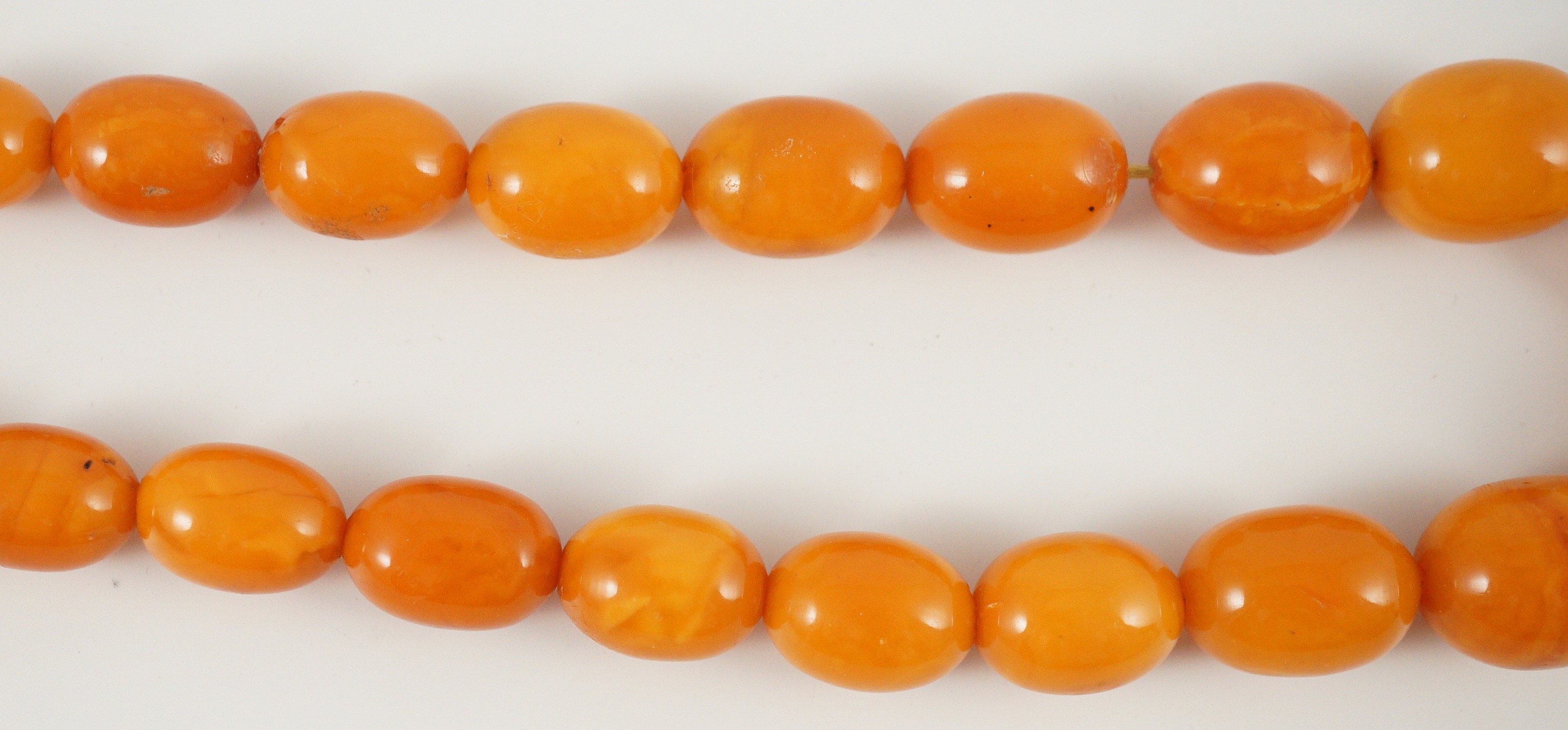 A single stand graduated oval amber bead necklace, 76cm, gross weight 85 grams.